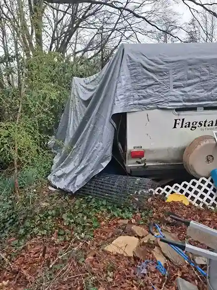 Camper covered with a tarp in the brush