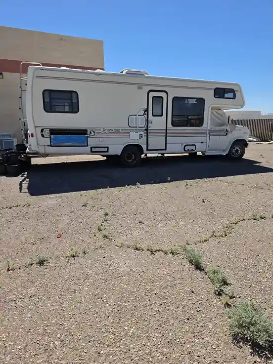 Class C RV parked on a gravel lot