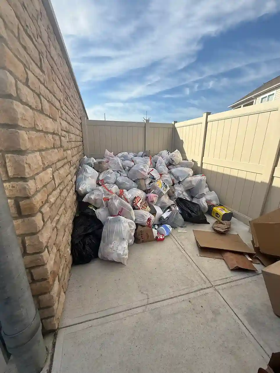 Trash and boxes piled in a side yard